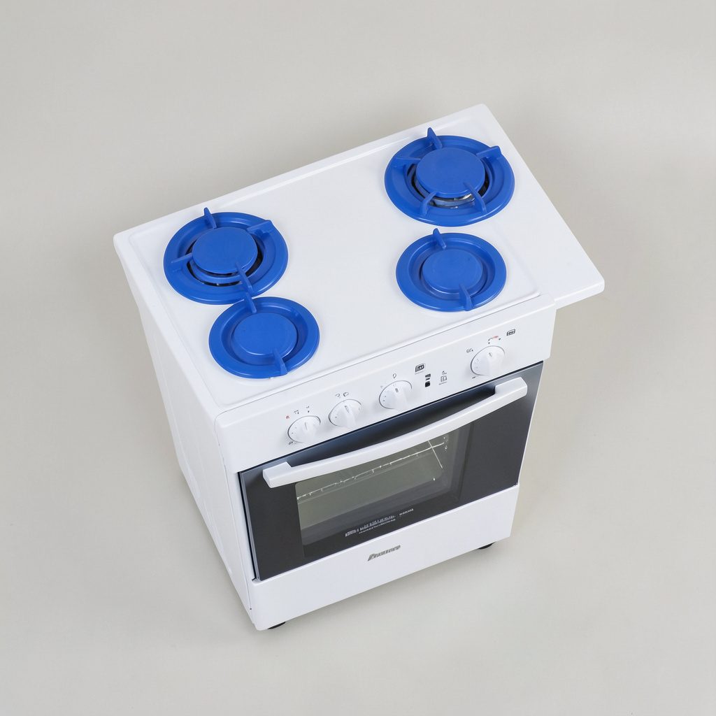 Photographie à plat d'une cuisinière blanche autonome avec table de cuisson à quatre foyers et four intégré, vue de trois-quarts sur fond neutre.
